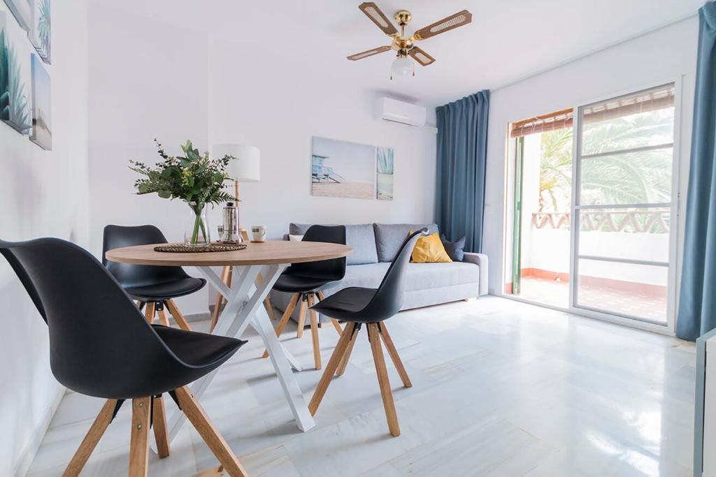 salon ze stołem i krzesłami w obiekcie Lovely 2 Bedroom Apartment w/ large garden + pools w mieście Benalmádena