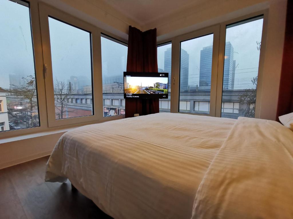 - une chambre avec un grand lit et une télévision dans l'établissement Ooostel2be Brussel, à Bruxelles