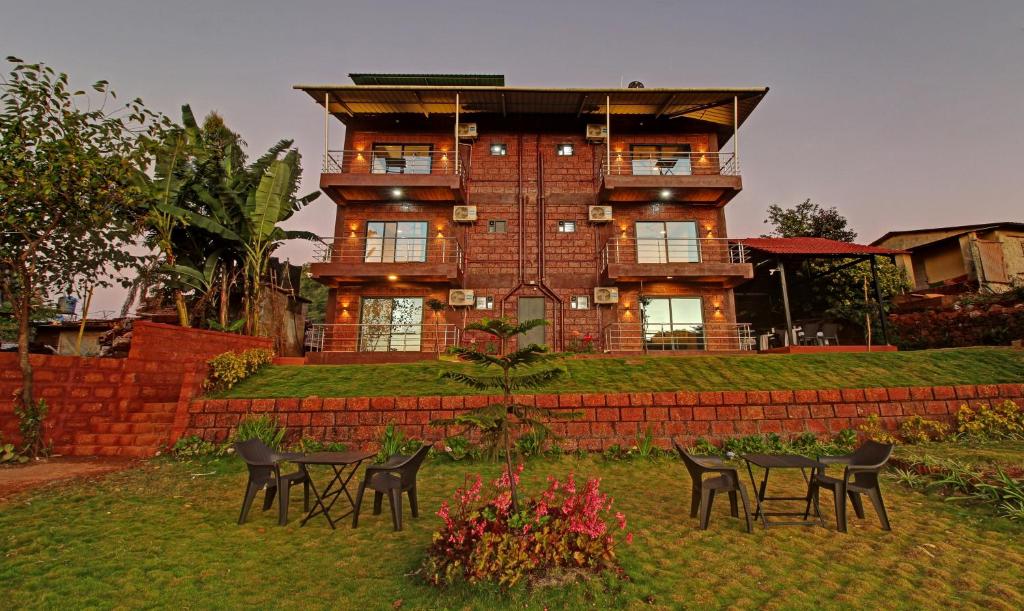 una casa grande con mesas y sillas delante de ella en Treebo Trend Raaya Regency, en Mahabaleshwar