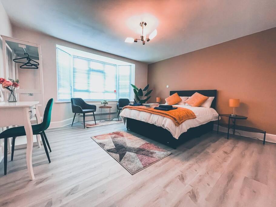 a bedroom with a bed and a table and chairs at Modern 3 ground floor Parking and Garden in Bournemouth