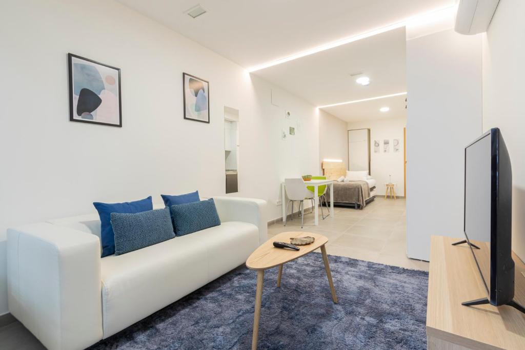 a living room with a white couch and a tv at dobohomes - Puenteareas in Madrid