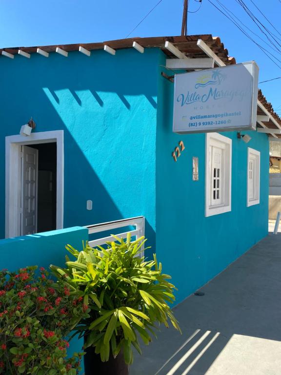 um edifício azul com um sinal em Villa Maragogi Hostel em Maragogi
