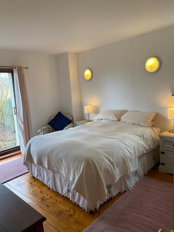 a bedroom with a large white bed and a window at Gorton House and Cottages in Lasswade