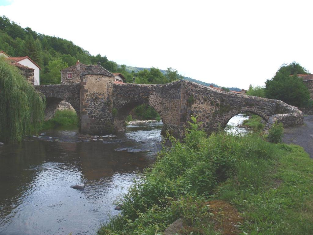 an old stone bridge over a river at Hotel Magne in Saurier
