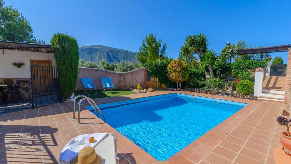 a swimming pool in a yard with a patio at Cortijo El Olivar Órgiva by Ruralidays in Órgiva