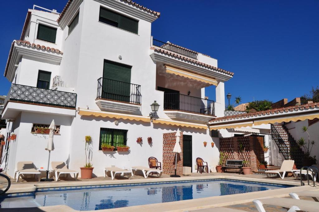 a villa with a swimming pool in front of a building at Biznaga Hols in Benalmádena