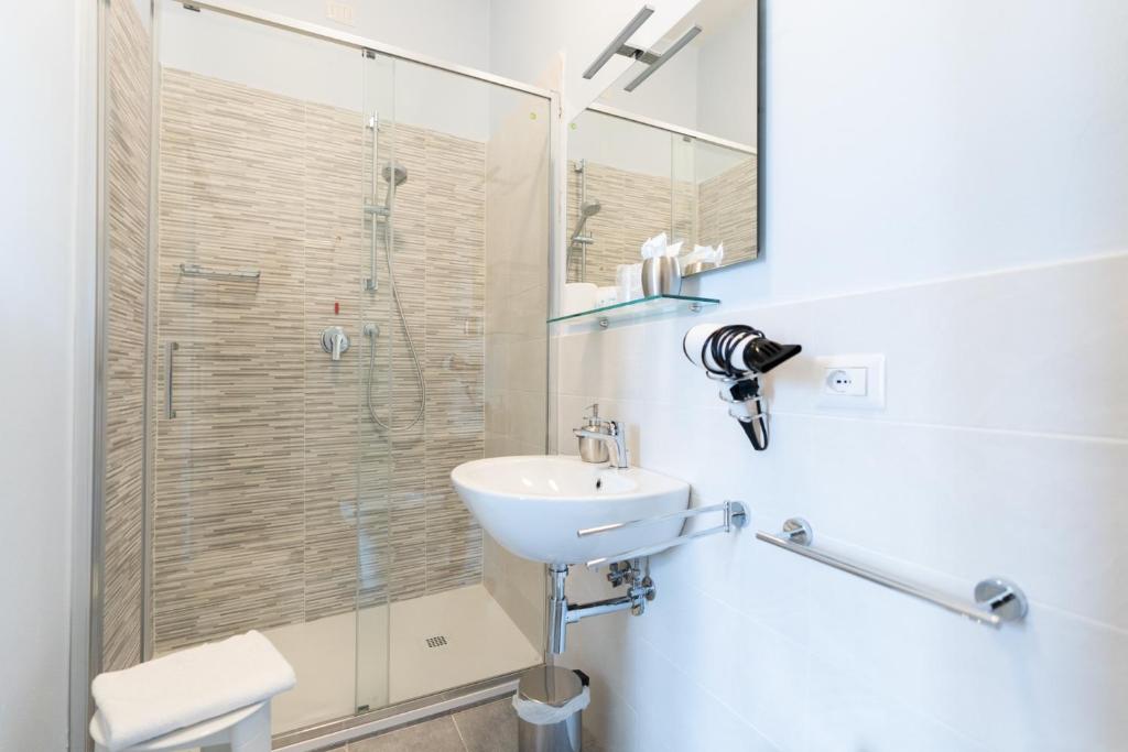 łazienka z umywalką i przeszkloną kabiną prysznicową w obiekcie Albergo Centrale w Sienie