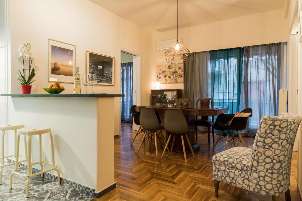 - une salle à manger et un salon avec une table et des chaises dans l'établissement Modern-Vintage apartment by Acropolis museum, à Athènes