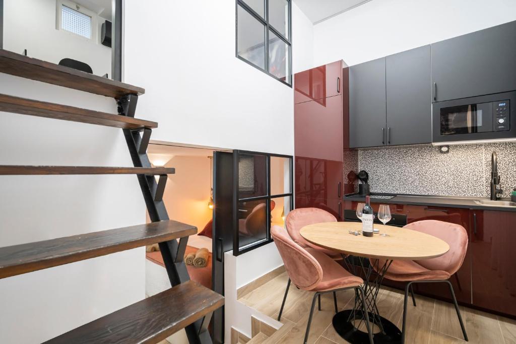 eine Küche und ein Esszimmer mit einem Holztisch und rosa Stühlen in der Unterkunft For You Rentals New Duplex Apartment Chamberí-Arapiles BDG46 in Madrid