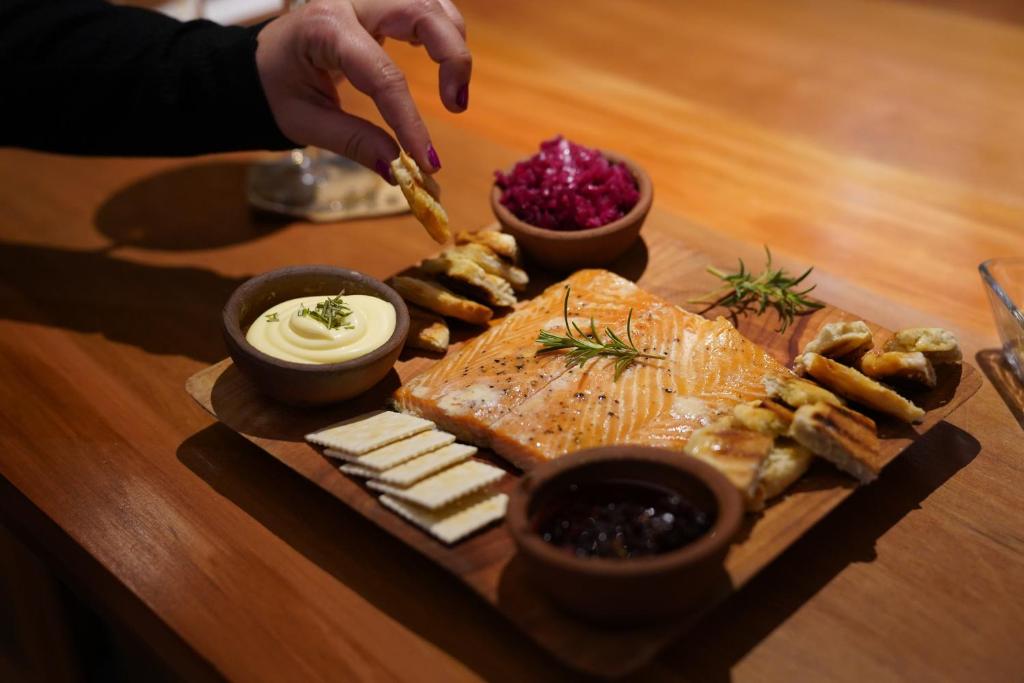 a plate of food with fish and cheese on a table at NI-NEWEN Hotel & Lodge in Pucón