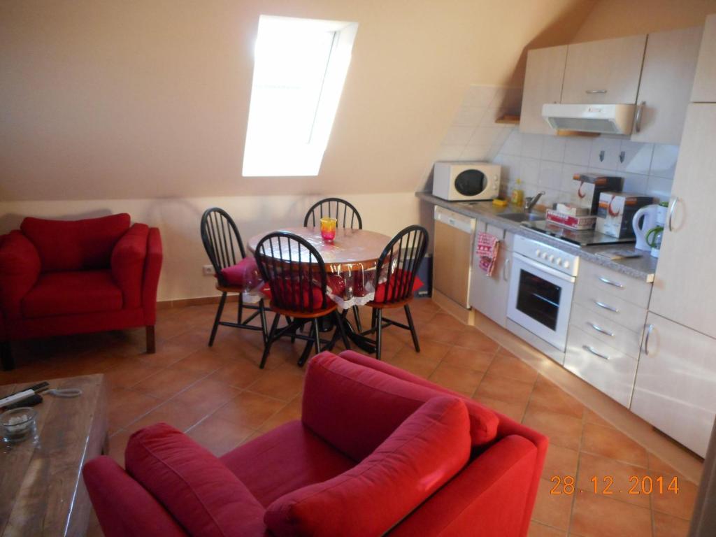 ein Wohnzimmer mit einem Tisch und Stühlen sowie eine Küche in der Unterkunft Sonnenblume in Landkirchen