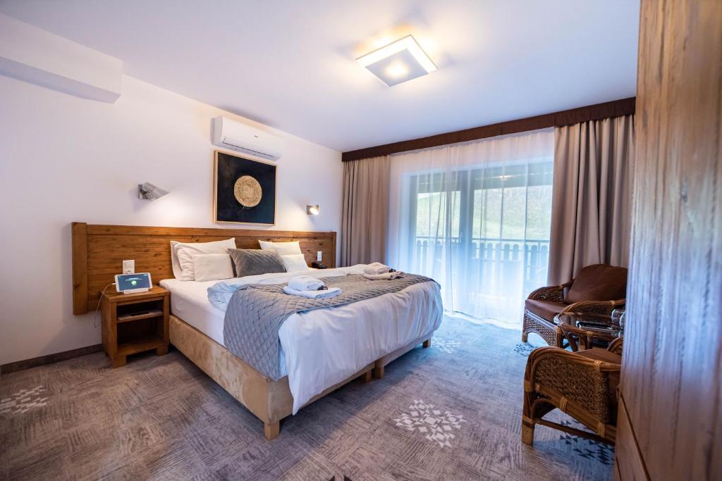 um quarto com uma cama, uma cadeira e uma janela em Apartamenty przy Hotelu Żywieckim em Przyłęków