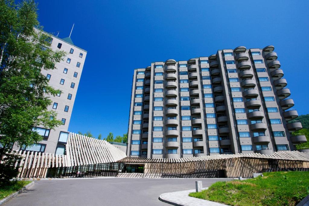 a tall building with a fence in front of it at One Niseko Resort Towers in Niseko