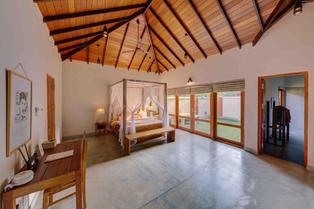 a large room with a bed and a room with a table at The Spice Trail in Arugam Bay