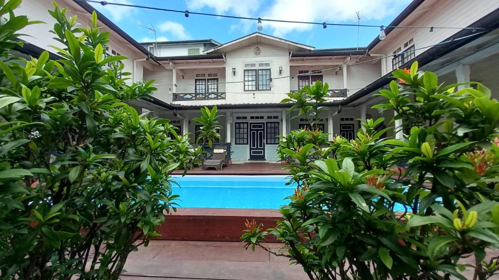 a house with a swimming pool in front of it at Zeelandia Suites in Paramaribo