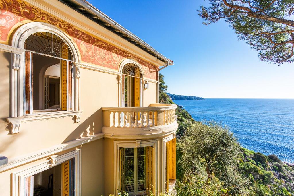 une maison avec un balcon donnant sur l'océan dans l'établissement Villa la Pescade by Riviera Holiday Homes VI4257, à Nice