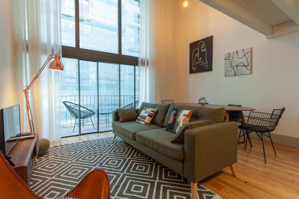 ein Wohnzimmer mit einem Sofa und einem Tisch in der Unterkunft Oporto City View- Trindade luxury in Porto