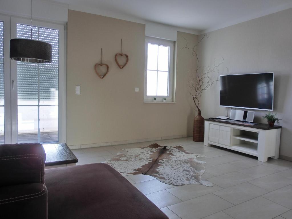 ein Wohnzimmer mit einem Sofa und einem Flachbild-TV in der Unterkunft Ferienwohnung LP8 "Deck Zwei" in Graal-Müritz