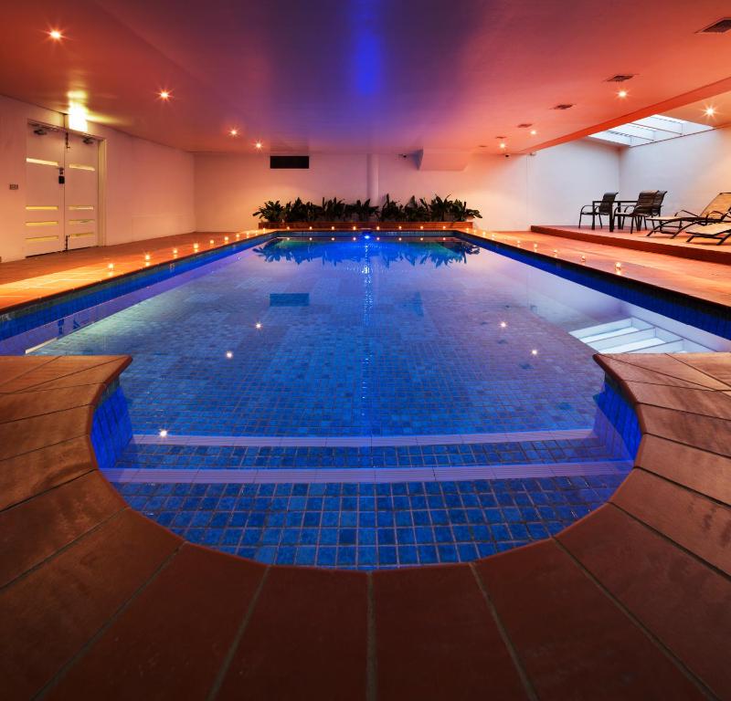 een groot zwembad met blauwe tegels op de vloer bij Canberra Parklands Central Apartment Hotel Official in Canberra