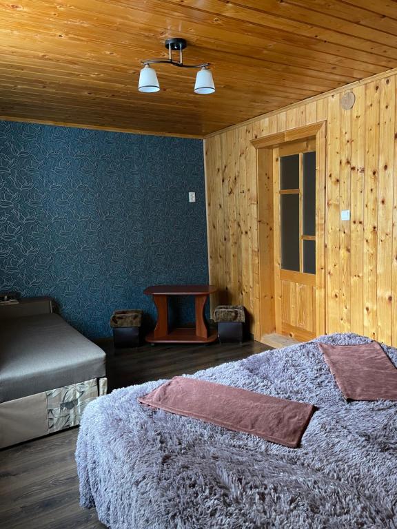 a bedroom with a bed and a wooden wall at Роздоріжжя in Yaremche