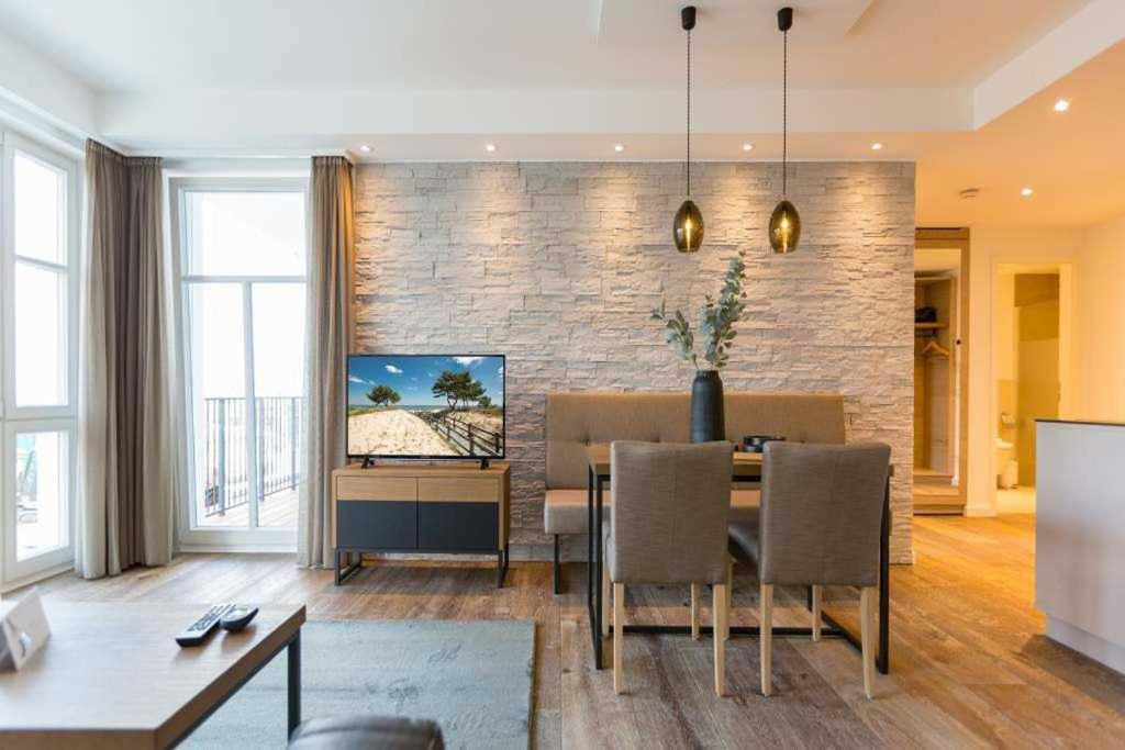 - un salon avec une table à manger et des chaises dans l'établissement Beachhouse Bansin App 08, à Bansin