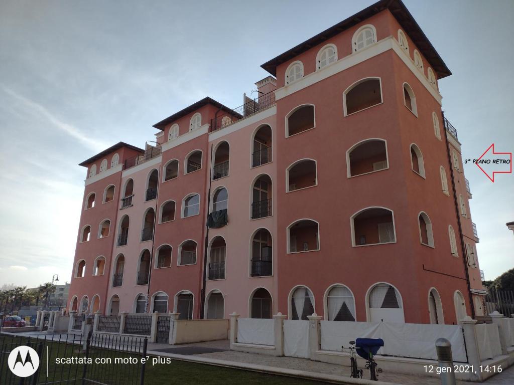 um grande edifício de tijolos vermelhos com muitas janelas em Appartamento Torri di Avvistamento em Porto Recanati