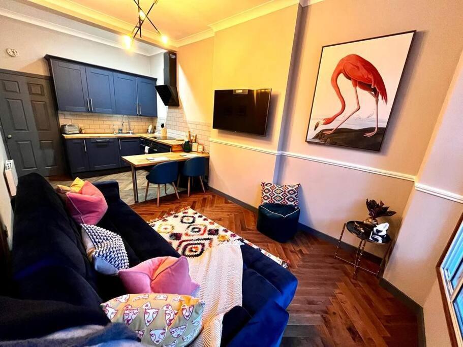 a living room with a couch and a kitchen at Stunning 1 bed Apt in West End in Glasgow