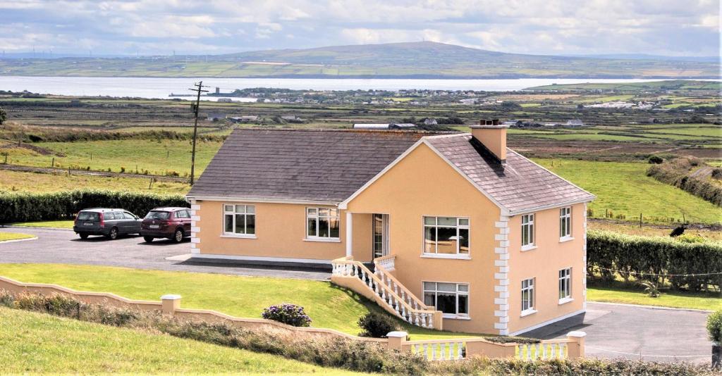 una casa en la cima de una colina con un estacionamiento en Hilltop B & B en Kilkee