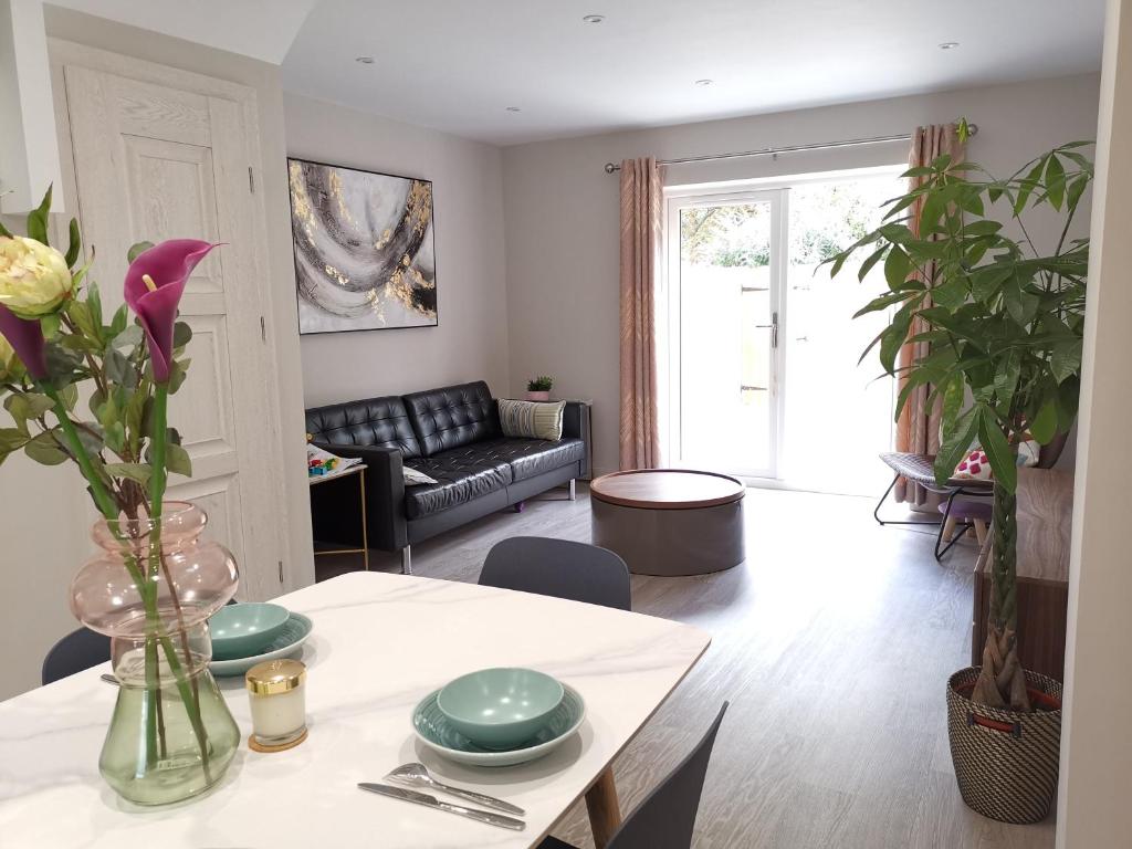 a living room with a table and a couch at Bournemouth cottage 6mins from beach, free parking in Bournemouth