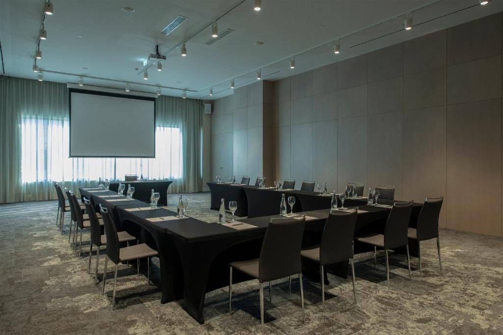 A formal meeting room arranged around a central conference table.