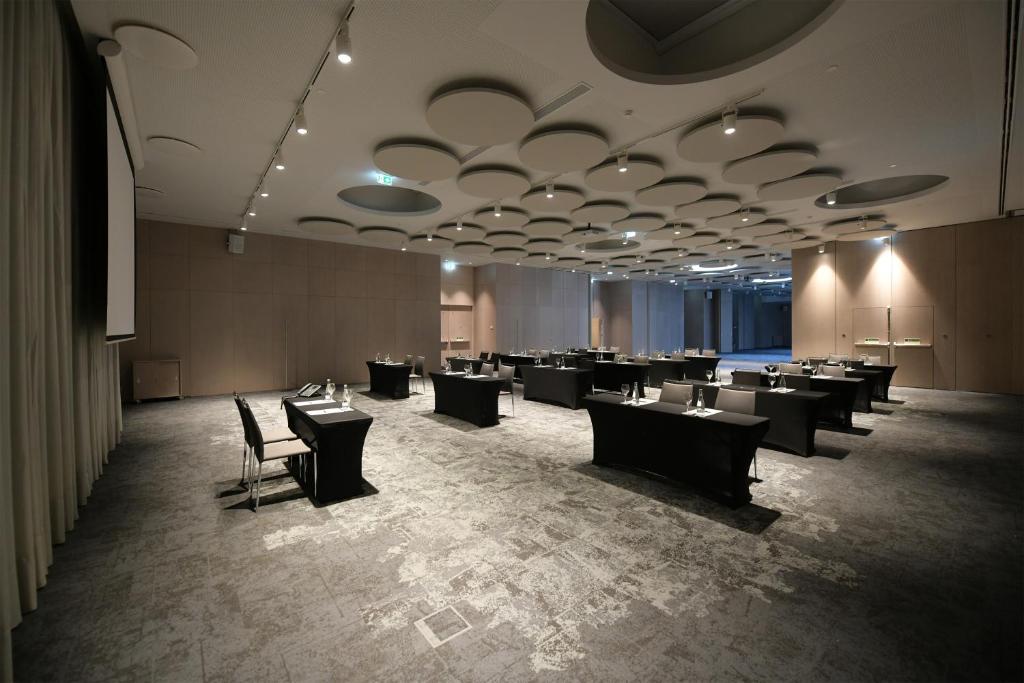 A large open event room with rows of dressed tables.
