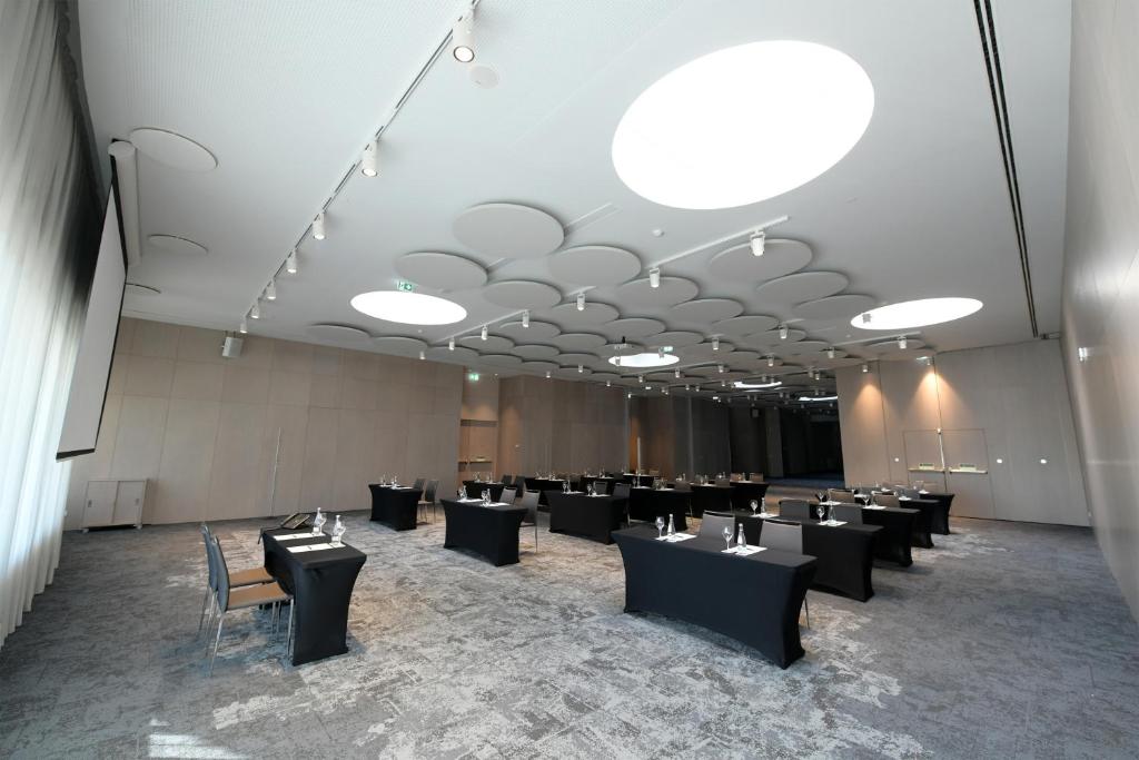 A broad event room arranged with separated banquet tables.