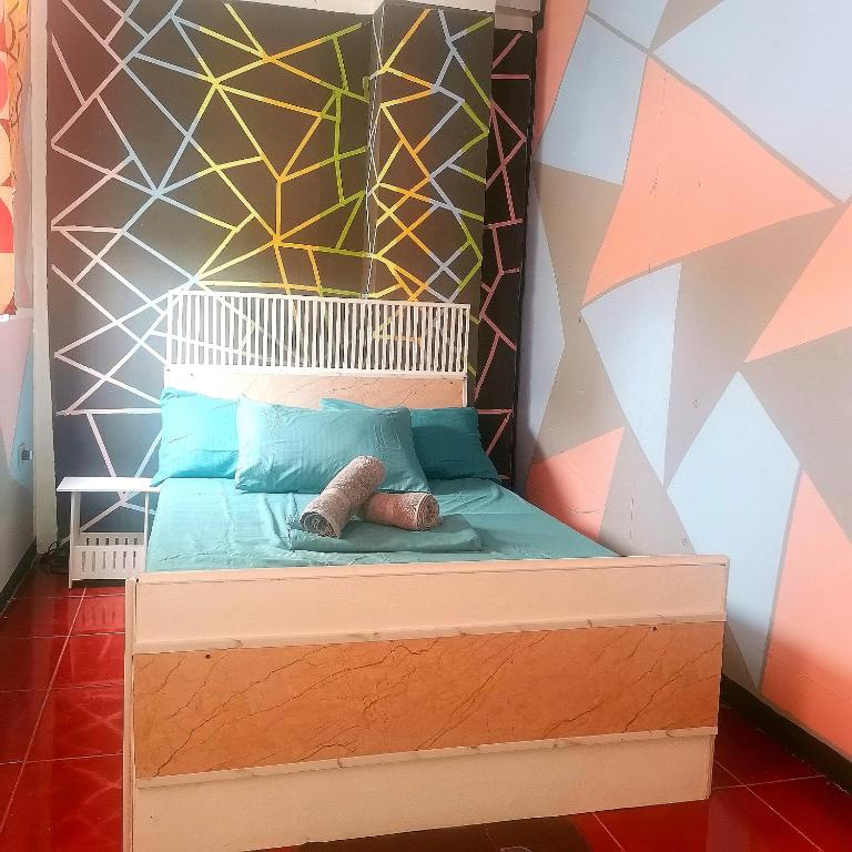 a bed in a room with a geometric wall at Cabanatuan City PNY TRANSIENT INN 4 in Cabanatuan