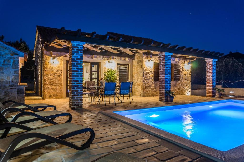 una villa con piscina di notte di Holiday Home Sandra a Sukošan (San Cassiano)