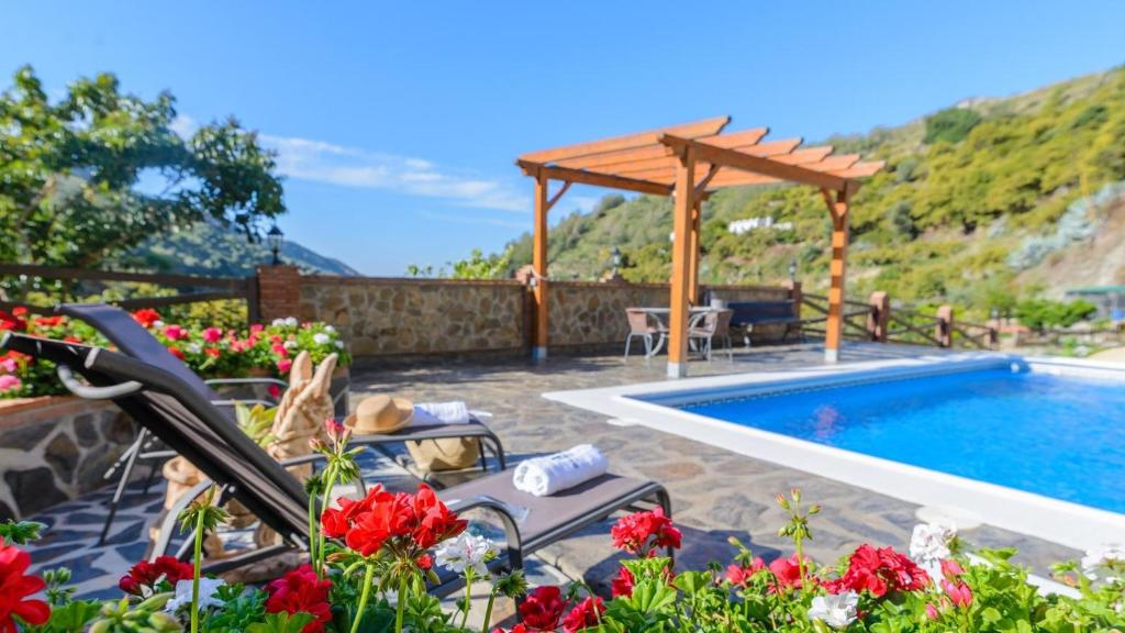 une terrasse avec une piscine et une pergola en bois dans l'établissement Villa La Cola Nerja by Ruralidays, à Nerja