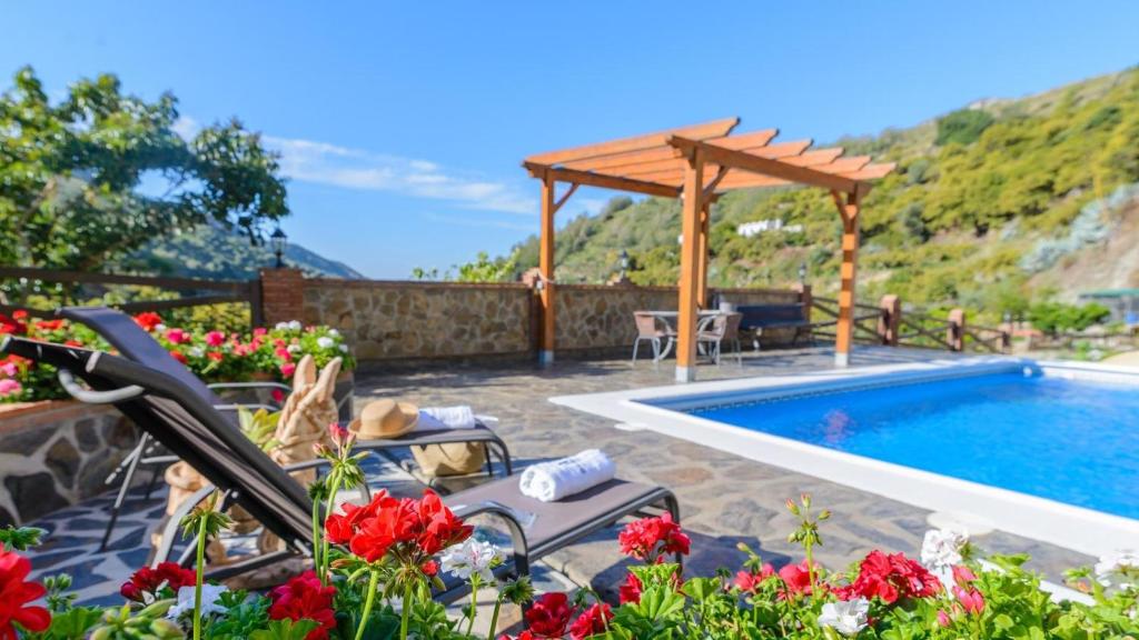 a patio with a pool and a wooden pergola at Villa La Cola Nerja by Ruralidays in Nerja
