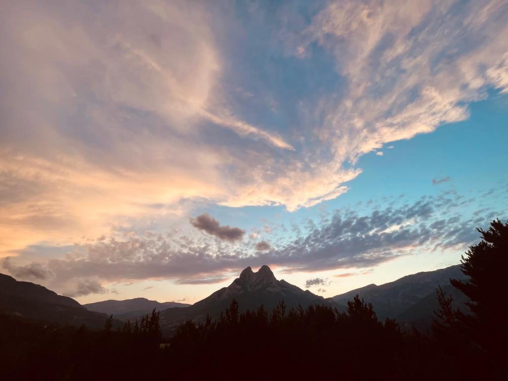 una montaña bajo un cielo nublado al atardecer en LA CARA NORD , ALOJAMIENTO TURISTICO ,SALDES, A LOS PIES DEL PEDRAFORCA, apartamento, en Saldes