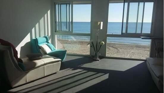 uma sala de estar com um sofá e vista para o oceano em Chalet Les Sirènes em Palavas-les-Flots