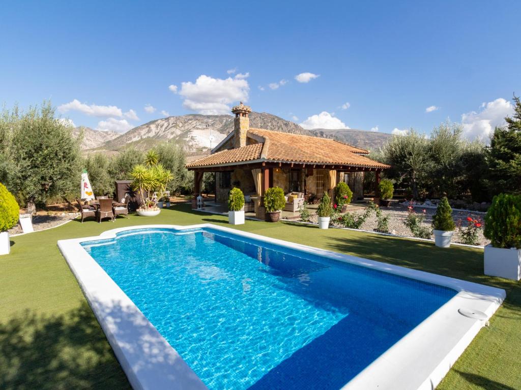 a villa with a swimming pool in front of a house at Bancalillo redondo in Dúrcal