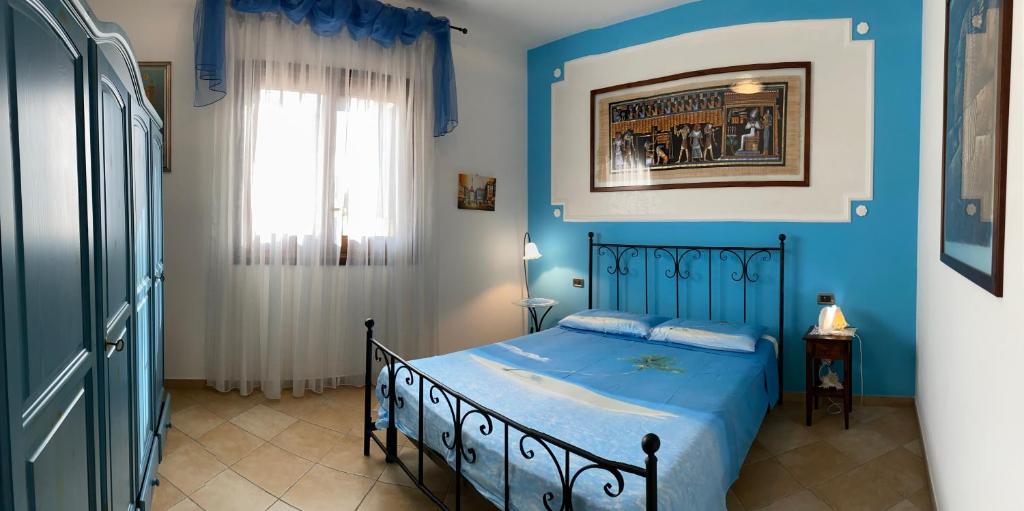 um quarto azul com uma cama e uma janela em Casa Vacanze Margherita em San Vito lo Capo