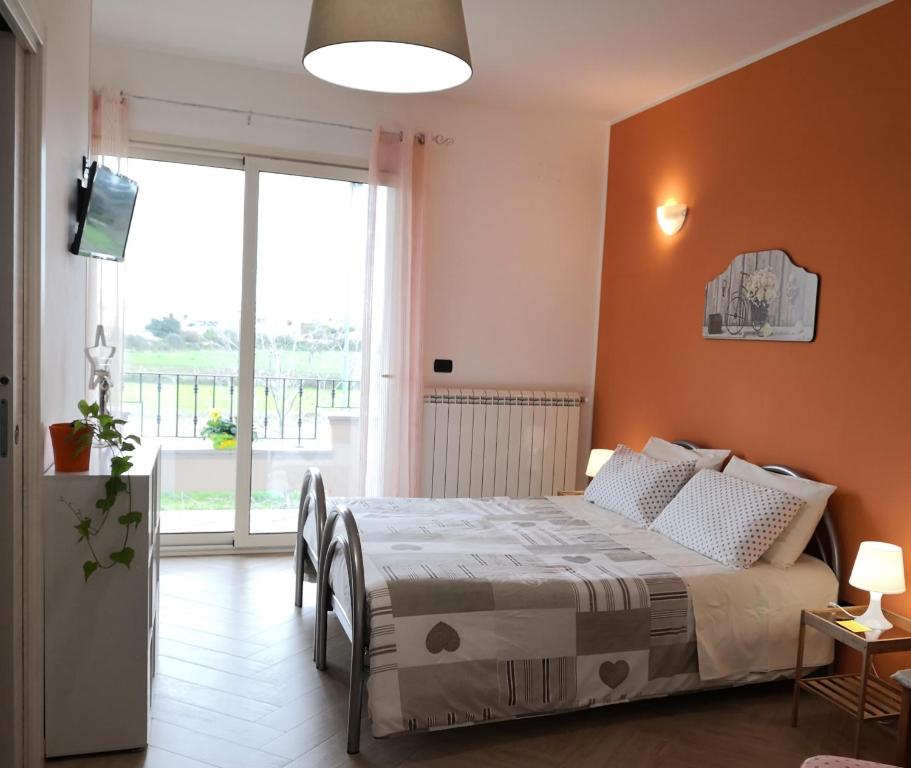 ein Schlafzimmer mit einem Bett und einem großen Fenster in der Unterkunft B&B Il Papavero Rosso in Corigliano dʼOtranto