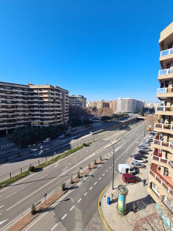 a city street with cars parked on the side of a road at Espacioso apartamento con impresionantes vistas y garaje privado - Dos Torres Tauriel in Zaragoza