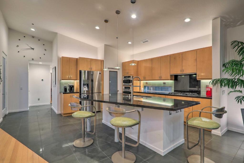 a kitchen with a counter and stools in it at Mid-Century Resort Home with Mtn and Golf Views! in Palm Springs