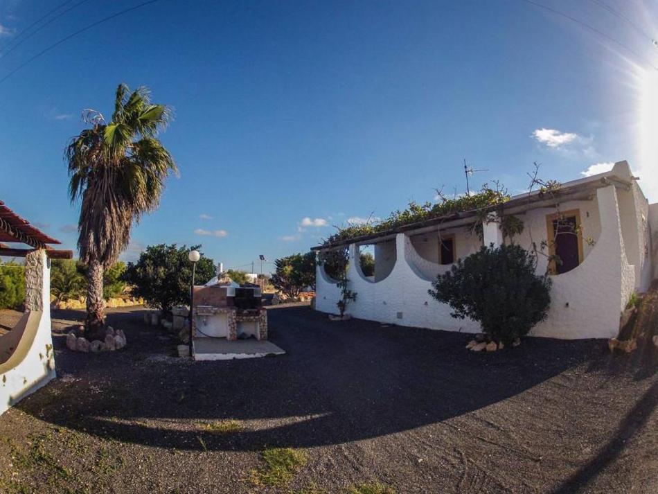 uma casa com uma palmeira em frente em Borgo Il Faro em Lampedusa
