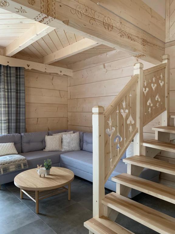 a living room with a blue couch and stairs at Pod Brzegiem - Domki góralskie in Czarny Dunajec