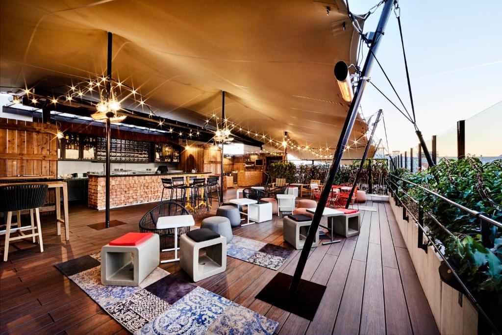 a rooftop bar with tables and chairs on a building at Generator Paris in Paris