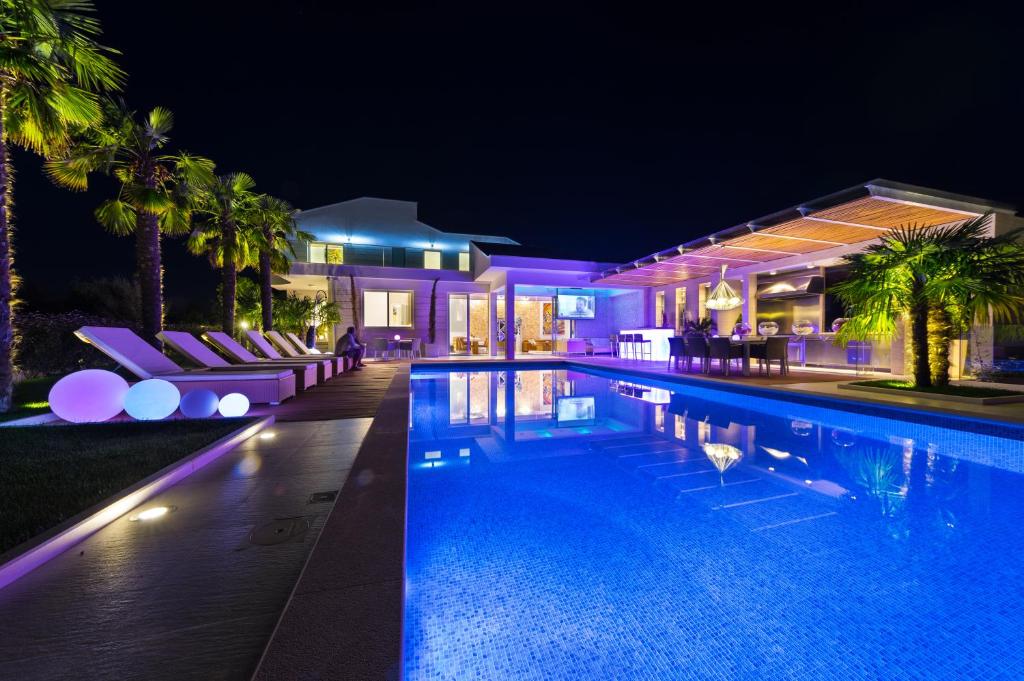 a house with a swimming pool at night at Villa Petra in Novalja