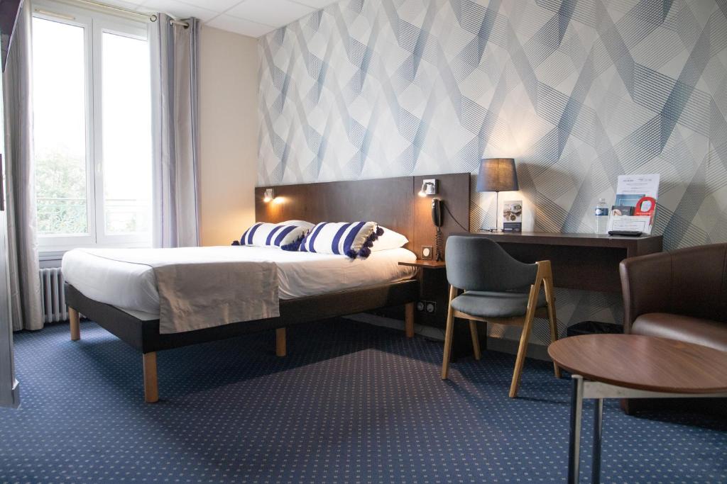 a bedroom with a bed and a desk and a chair at Hotel Bellevue in Brest