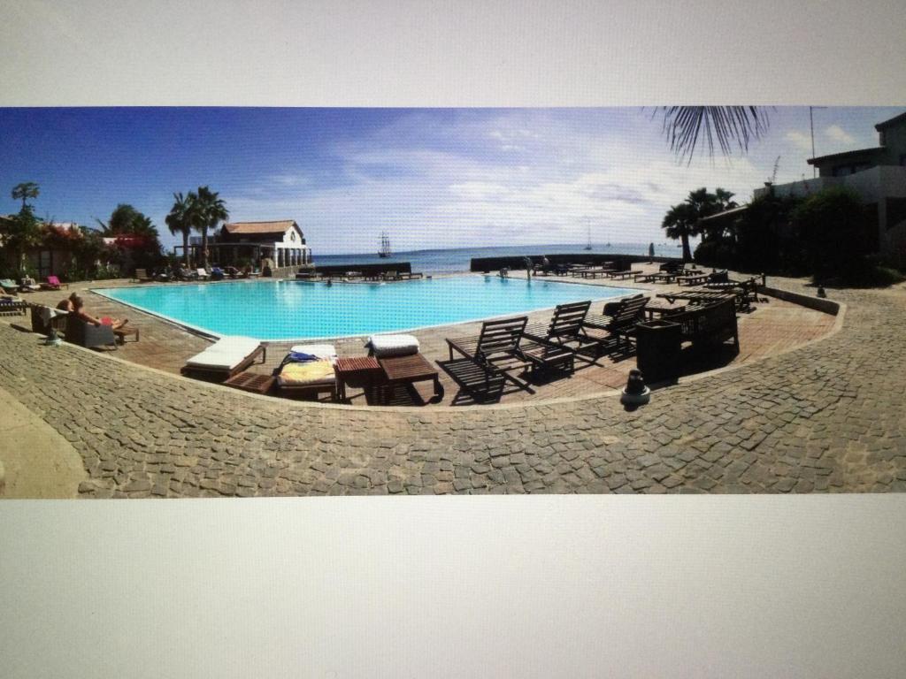 una gran piscina con tumbonas y sillas en Apt14 Porto Antigo 1 with Pool and Beach views en Santa María