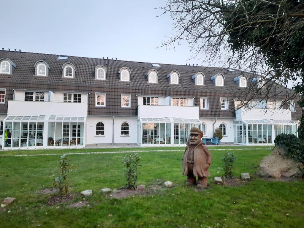 una estatua en el césped frente a un edificio en Ferienwohnung MeerGlück in der Ostseeresidenz Gandarm, en Wischuer